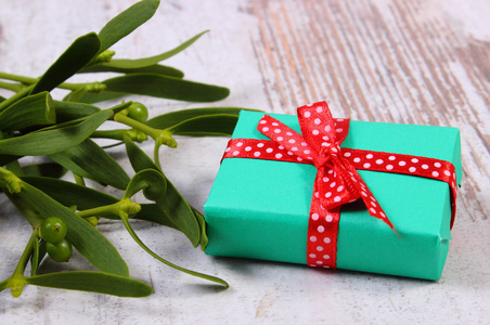 包装的绿色礼品，圣诞节和槲寄生在老木背景
