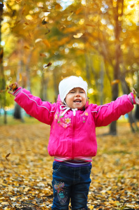 小女孩笑着，在秋天嬉戏