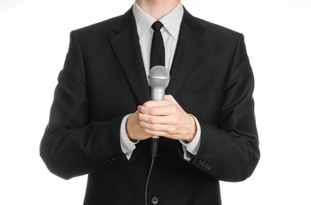 握话筒业务和演讲主题: 握着灰色的麦克风在工作室中孤立白色背景上的