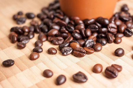 杯子和木制背景上的咖啡豆