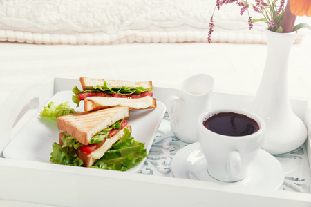 早餐在床上吃三明治和咖啡的木制托盘上
