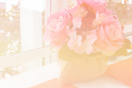 假粉红色玫瑰在白色的桌子附近的窗口与花园的看法 科洛
