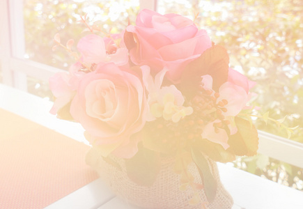 假粉红色玫瑰在白色的桌子附近的窗口与花园的看法 科洛