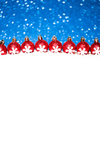 圣诞红球在雪上蓝色光圈背景