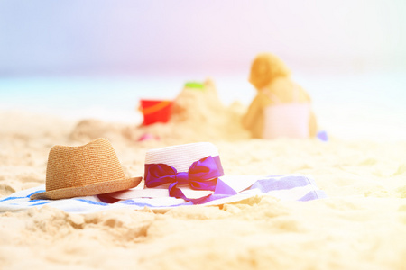 家庭海滩度假概念帽子和孩子玩沙子
