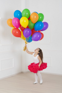 小女孩玩着五颜六色的气球在工作室