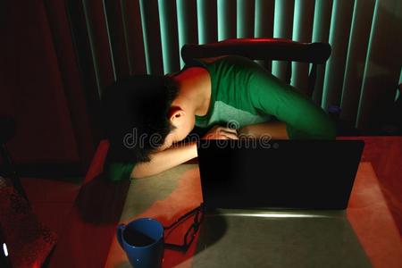 在笔记本电脑前睡觉的青少年