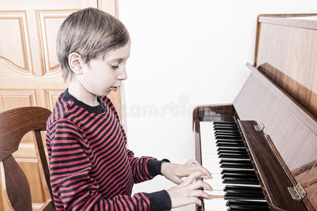 可爱的小男孩弹钢琴，表情滑稽