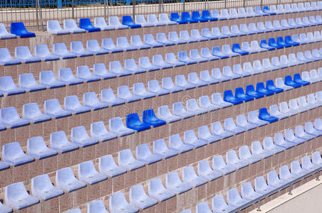 一排排浅蓝色和深蓝色塑料体育场座椅