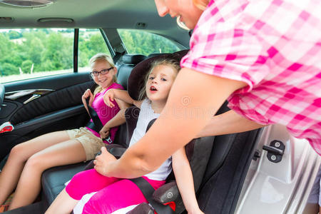 母亲系好儿童车安全座椅