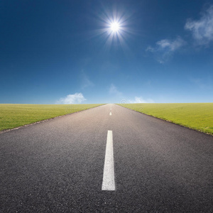 在空旷的道路上向太阳驶去照片