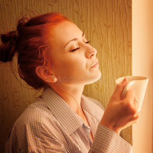 一大早美女在窗前喝着咖啡