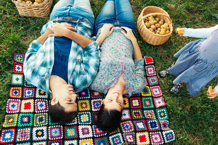 秋天躺在草地上毯子上的一对夫妇