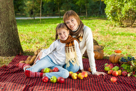 快乐的妈妈和小女儿在秋天公园