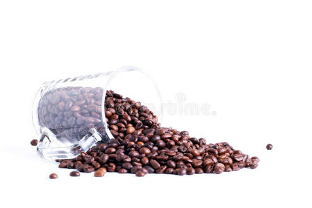 咖啡豆从隔离在白色背景上的玻璃杯中溢出