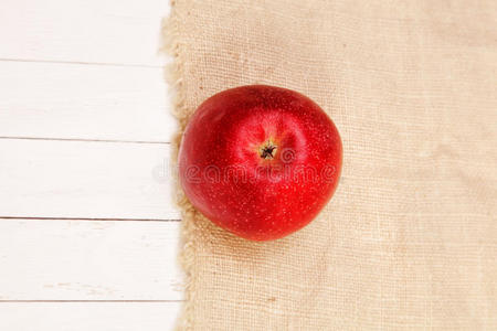 红苹果放在粗麻布和白桌子上