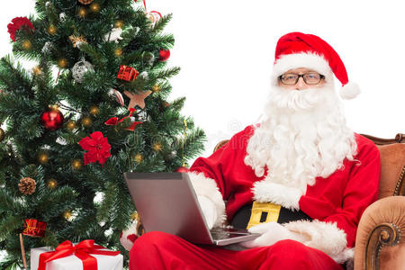 圣诞老人装扮的男人拿着笔记本电脑