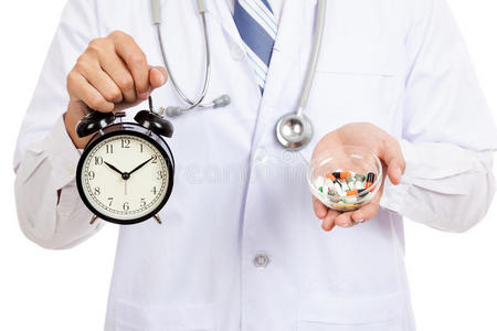 亚洲男医生展示时钟和药丸