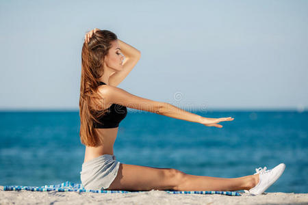 这位年轻女子在海滩上进行移动训练。