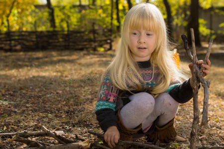 小女孩在户外拾柴照片