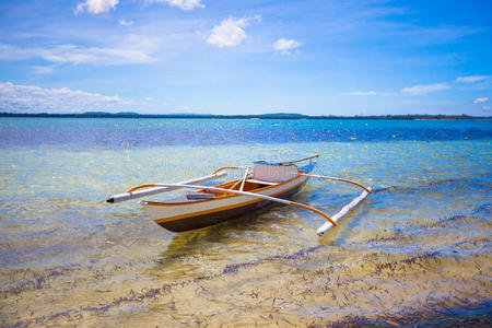 白色热带海滩上的小渔船