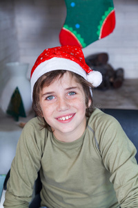 小男孩在家里戴着红色圣诞老人帽