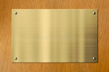 空白牌匾木质背景上的金或黄铜金属牌匾照片
