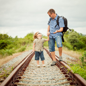 快乐的一家人白天在铁路上散步。