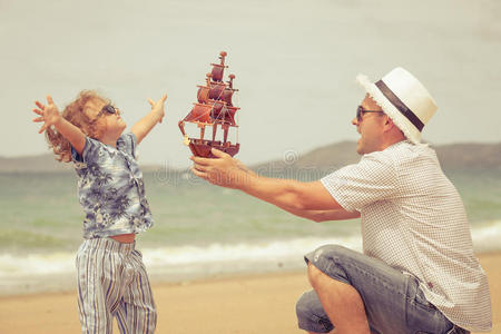 爸爸和儿子白天在海滩上玩耍。