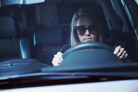 开车转弯戴墨镜开车的年轻女子照片