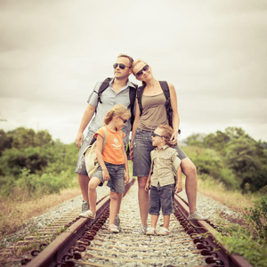 快乐的一家人白天在铁路上散步。