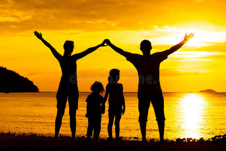 在海滩上玩耍的快乐家庭的剪影