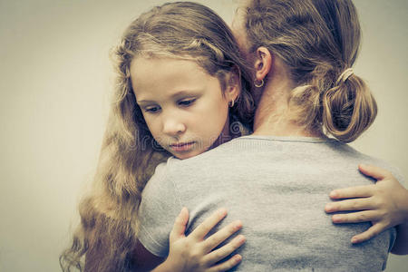一个悲伤的女儿拥抱他的母亲的画像