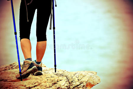 走在海边山路上的女徒步旅行者的腿