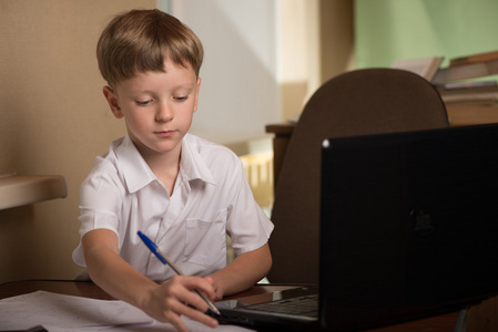 男孩在桌上的笔记本电脑