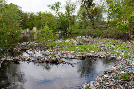 河上的垃圾小垂死的河流布满了沼泽植物.周围的污染, 藻类的快速生长.