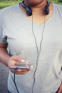 女人在耳机与智能手机上听音乐