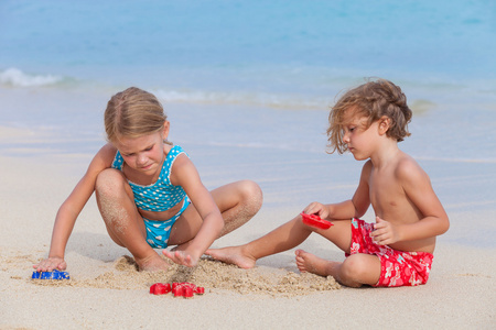 两个快乐的孩子们在沙滩上玩