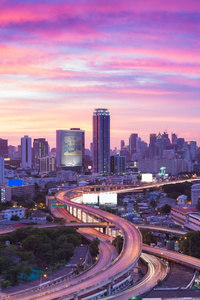 在黄昏，泰国在曼谷立交桥的戏剧性的天空的现代城市天际线的交汇处