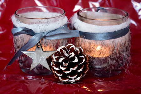 圣诞节的红色背景与茶蜡烛烛台装饰着木制的驯鹿，松锥和圣诞球