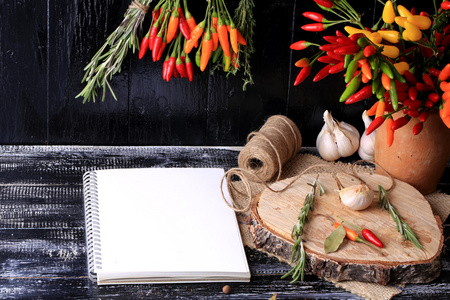 香料和佐料笔记本为食谱束香料辣椒迷迭香百里香深色木材背景复古风格封面为一本烹饪书 的背景