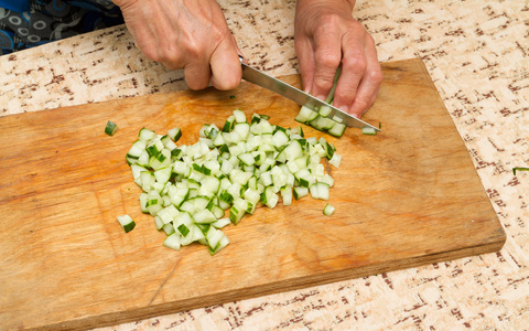 厨师在木板上切黄瓜