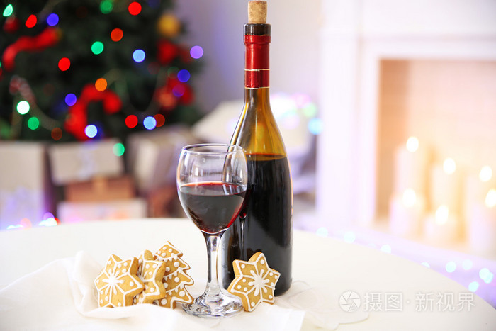酒瓶和酒杯的酒与圣诞装饰丰富多彩的散景灯背景