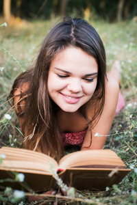 在公园的年轻漂亮的白人女性阅读本书