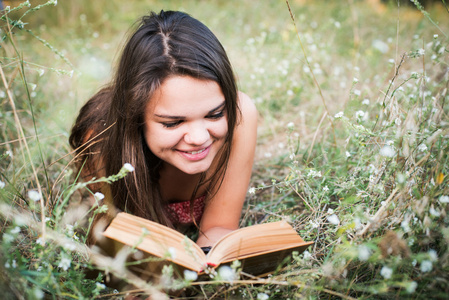 在公园的年轻漂亮的白人女性阅读本书