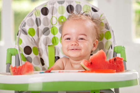 微笑美丽的宝宝在厨房吃西瓜