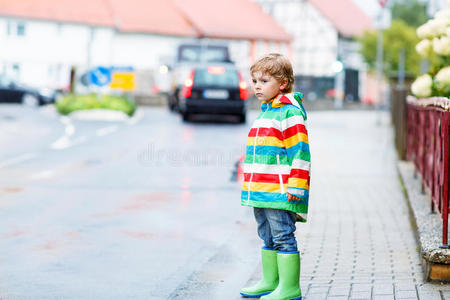 快乐可爱的小男孩在雨中漫步