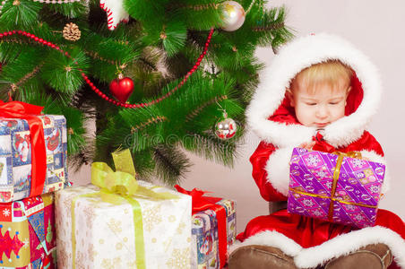 圣诞树上穿着圣诞老人服装的婴儿