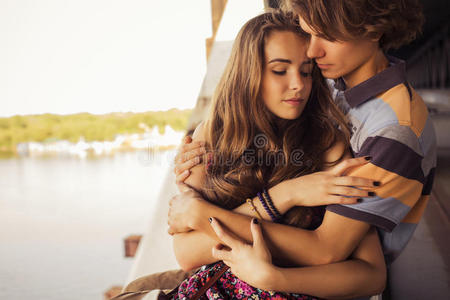 夏日的阳光下，一对年轻夫妇在城外的一座桥上拥抱。复制空间