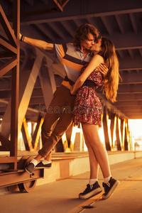 一对年轻夫妇在c桥上的夕阳余晖中接吻